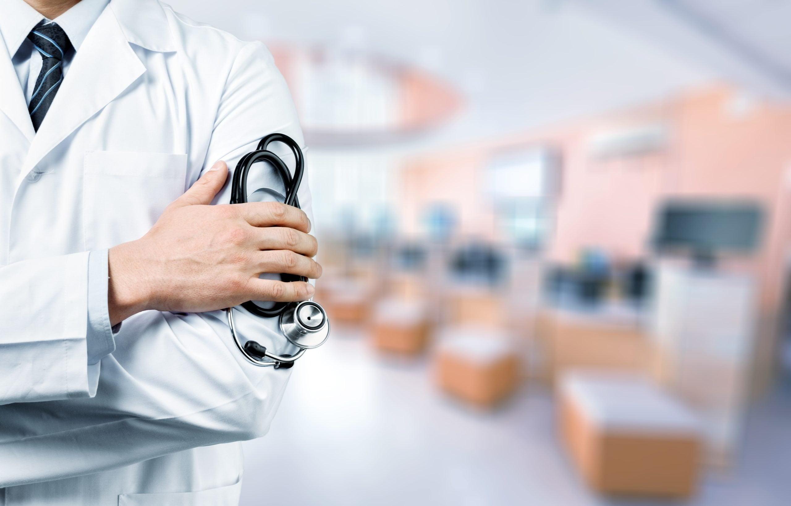 Young,Man,Doctor,Holding,A,Stethoscope,On,Background
